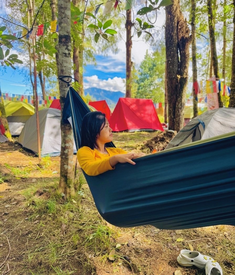 Guest resting in a hammock at the forest campsite